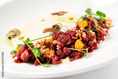 plate with delicious tartare and mushroom puree. Isolated on the white background