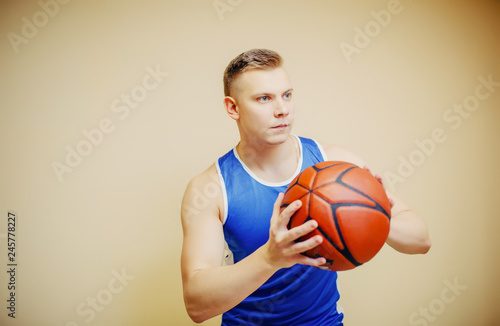 Basketball player about to shoot a ball. Concentrated man dressed in light blue tank top © hamster