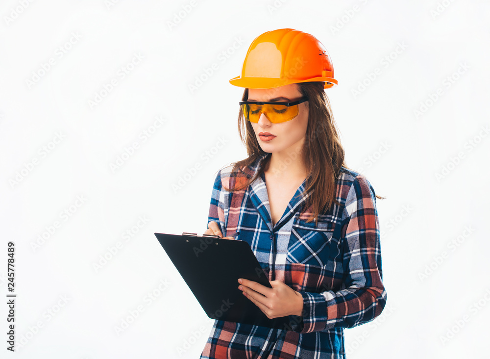 Beautiful serious female architect with writing business plans isolated on white. Attractive worker in helmet and glasses holds black folder Beautiful serious female architect with writing business plans isolated on white. Attractive worker in helmet and glasses holds black folder