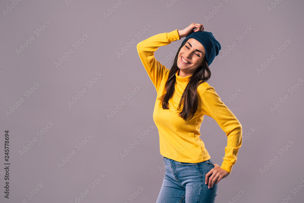 Beautiful happy young brunette hipster woman in yellow isolated on grey background Beautiful happy young brunette hipster woman in yellow isolated on grey background