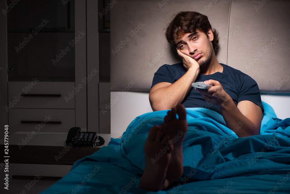 Man watching tv at night in bed Stock Photo Adobe Stock