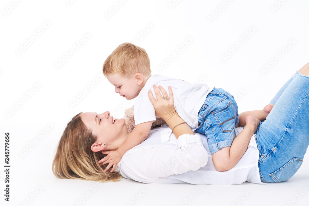 Happy young mother having fun with her toddler child - Son hugging his mum on white background - Family lifestyle, motherhood, love and tender moments concept Happy young mother having fun with her toddler child - Son hugging his mum on white background - Family lifestyle, motherhood, love and tender moments concept
