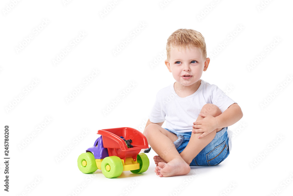Cute boy plaing with toy car on floor, isolated on white Cute boy plaing with toy car on floor, isolated on white