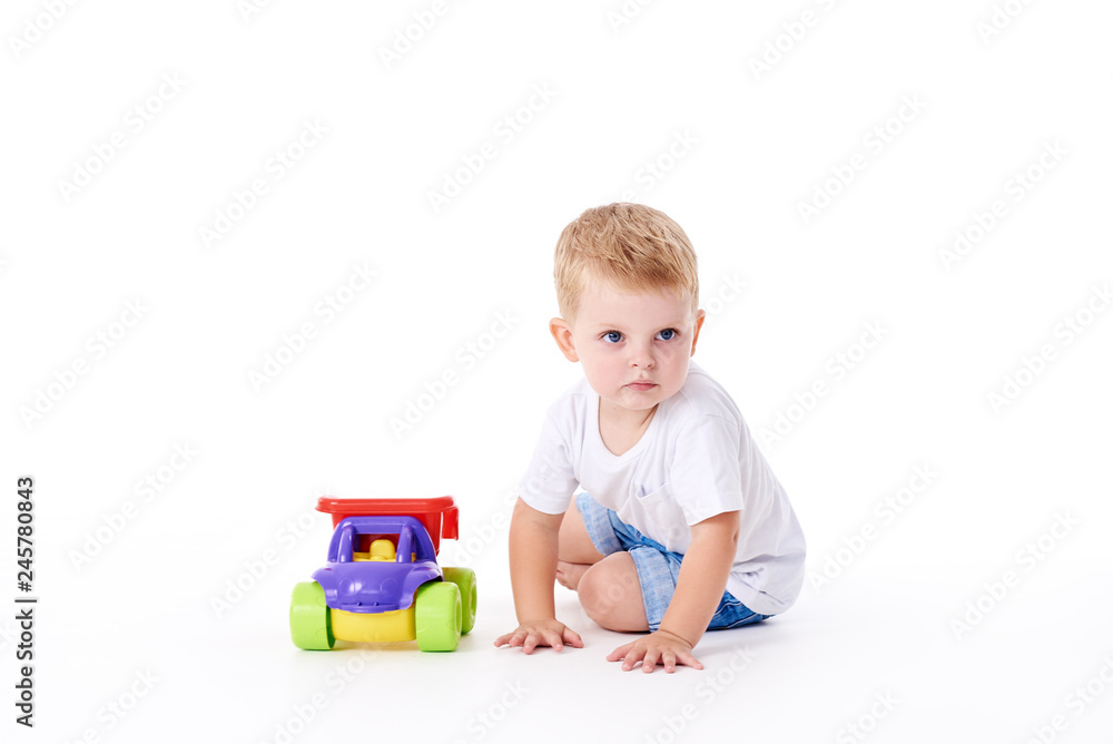 Cute boy plaing with toy car on floor, isolated on white Cute boy plaing with toy car on floor, isolated on white