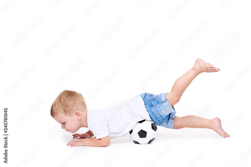 Little cute kid baby boy 3 years old, football fan in white t-shirt playing with soccer ball isolated on white background. lifestyle concept. Copy space for text Little cute kid baby boy 3 years old, football fan in white t-shirt playing with soccer ball isolated on white background. lifestyle concept. Copy space for text