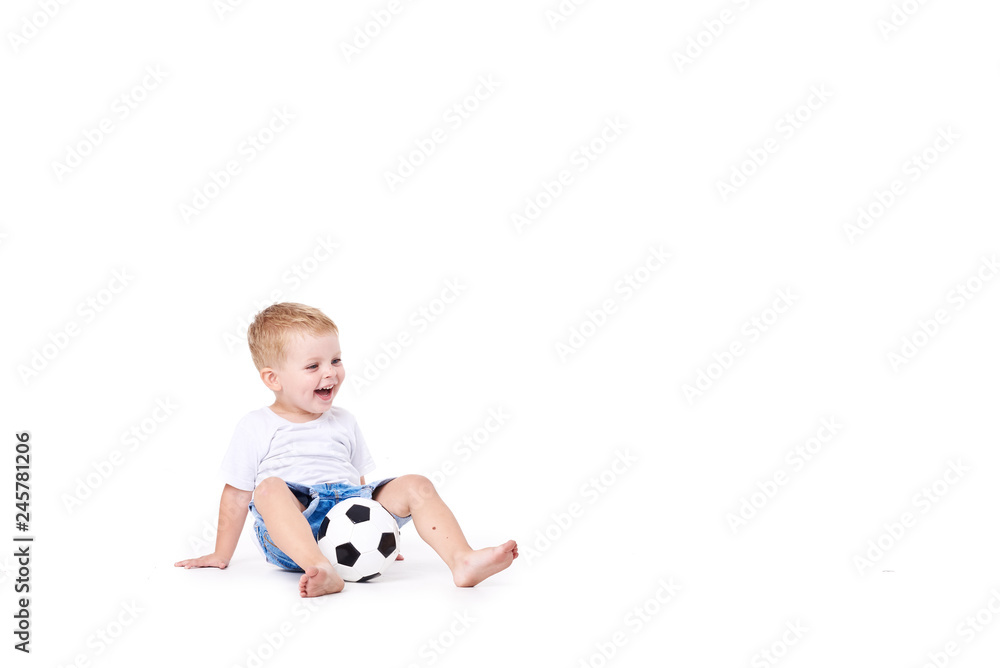Little cute kid baby boy 3 years old, football fan in white t-shirt playing with soccer ball isolated on white background. lifestyle concept. Copy space for text Little cute kid baby boy 3 years old, football fan in white t-shirt playing with soccer ball isolated on white background. lifestyle concept. Copy space for text