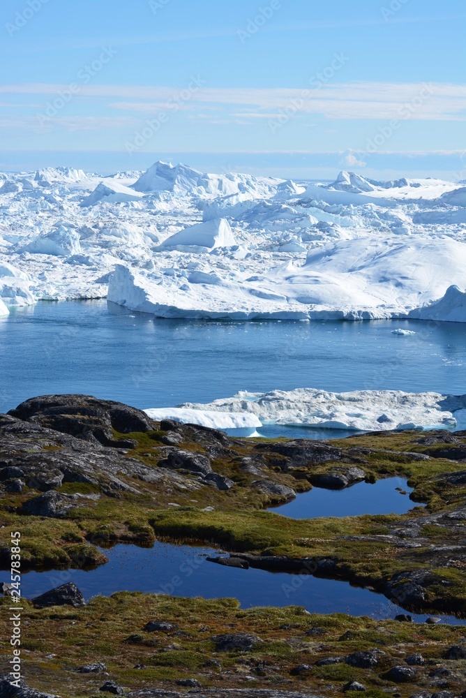 Ilulissat, Greenland, July | UNESCO world heritage site | impressions of Jakobshavn | Disko Bay Kangia Icefjord | huge icebergs in the blue sea on a sunny day | climate change - global warming