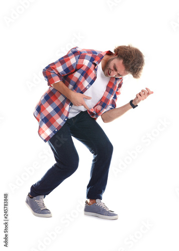 Young man playing air guitar on white background