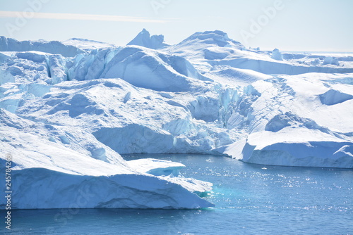 Ilulissat  Greenland  July   UNESCO world heritage site   impressions of Jakobshavn   Disko Bay Kangia Icefjord   huge icebergs in the blue sea on a sunny day   climate change - global warming