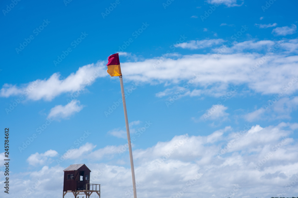 Lifeguard flag against clear blue sky Lifeguard flag against clear blue sky