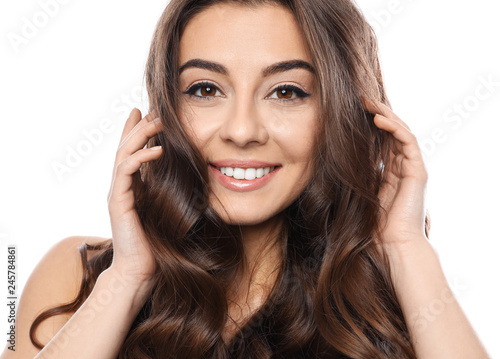 Beautiful woman with shiny wavy hair on white background
