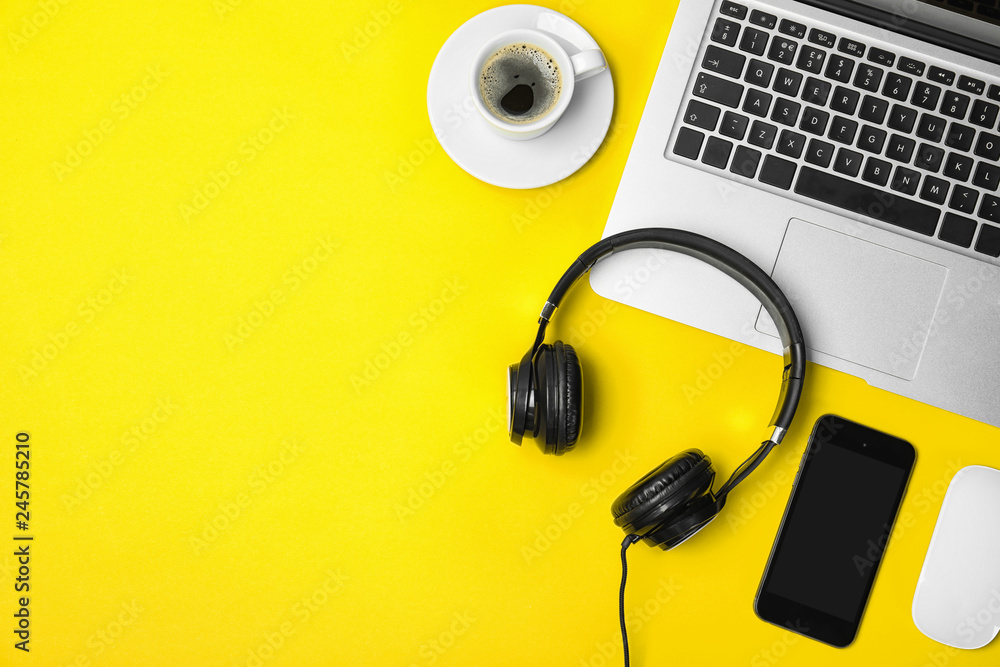 Flat lay composition with headphones, smartphone, laptop and space for text on color background Flat lay composition with headphones, smartphone, laptop and space for text on color background