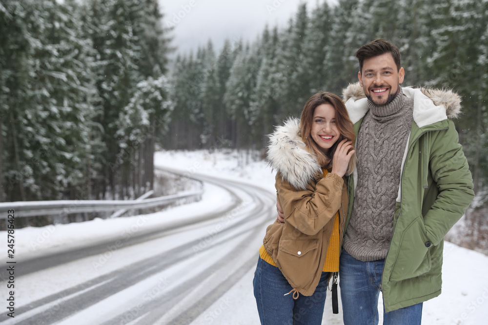 Couple walking near snowy forest, space for text. Winter vacation Couple walking near snowy forest, space for text. Winter vacation