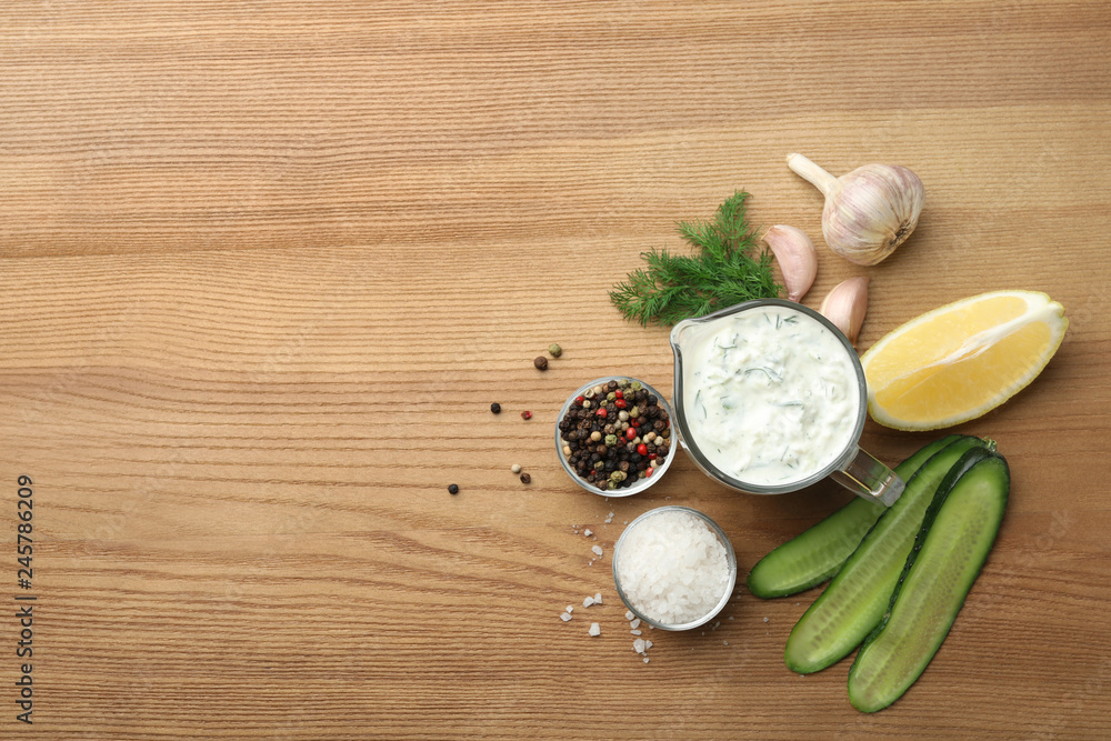 Cucumber sauce, ingredients and space for text on wooden background, flat lay. Traditional Tzatziki Cucumber sauce, ingredients and space for text on wooden background, flat lay. Traditional Tzatziki