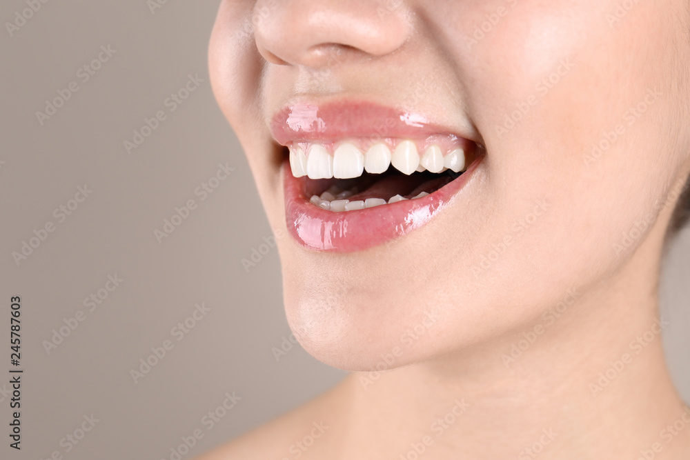 Obraz premium Beautiful young woman with healthy teeth on color background, closeup