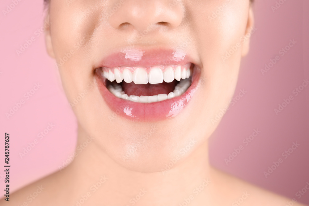 Obraz premium Beautiful young woman with healthy teeth on color background, closeup