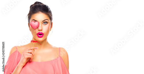 Valentines Day. Beauty joyful young fashion model girl with Valentine heart shaped cookie in her hand isolated on white