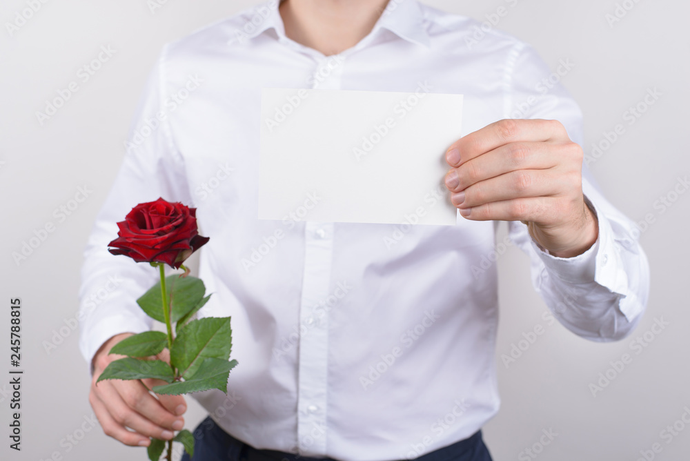Cropped closeup photo portrait of handsome happy charming cheerful glad guy holding small post card in hands showing to you camera isolated grey background copy space Cropped closeup photo portrait of handsome happy charming cheerful glad guy holding small post card in hands showing to you camera isolated grey background copy space