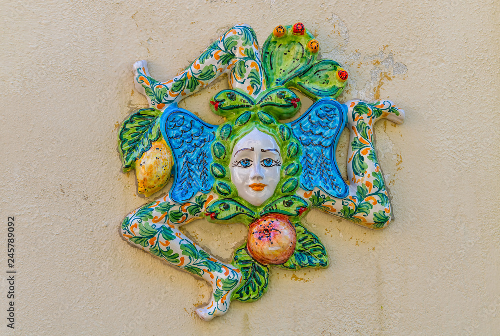 A typical ceramic figure Trinacria, the symbol of Sicily, hanging along the streets of Ragusa, Italy