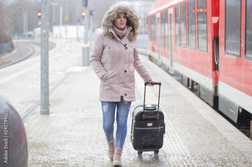 Junge Frau mit Koffer am Bahnhof  © Waler