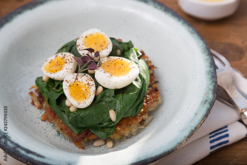 Rosti topped with spinach and quail eggs
