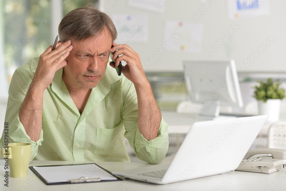 Mature businessman working at table with laptop Mature businessman working at table with laptop