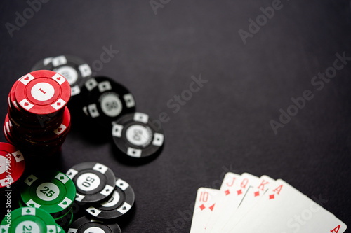 Casino chips and playing cards on minimalistic black background. Royal flash.