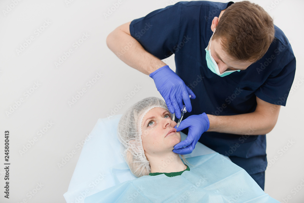 girl do plastic operation in medical clinic; doctor does lip augmentation surgery; injecting operation on lips girl do plastic operation in medical clinic; doctor does lip augmentation surgery; injecting operation on lips