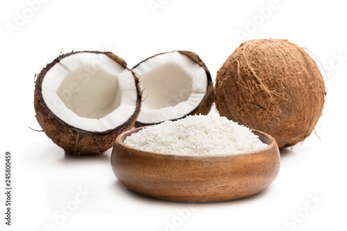 Desiccated coconut in wooden bowl isolated on white