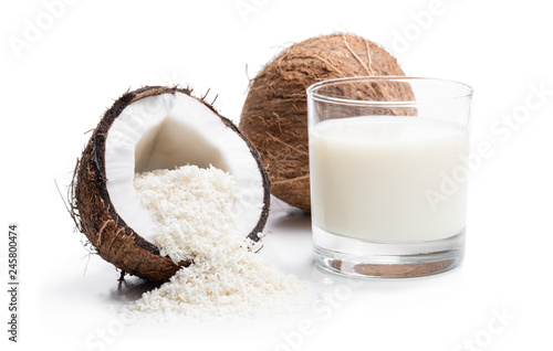 Glass of fresh coconut milk and flakes isolated on white photo