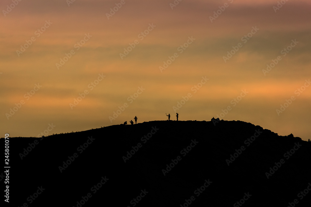 anochecer con silueta de personas en una montaña anochecer con silueta de personas en una montaña