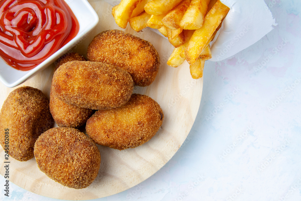 Upper of view of ham and chicken croquettes with chips and fried tomato