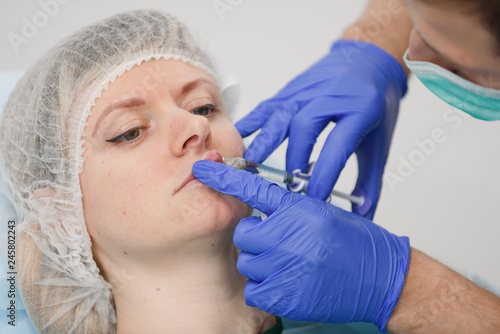 girl do plastic operation in medical clinic  doctor does lip augmentation surgery  injecting operation on lips