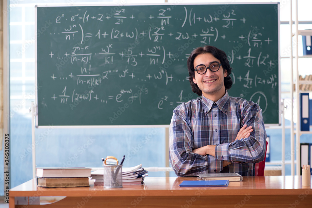 Young funny math teacher in front of chalkboard Young funny math teacher in front of chalkboard