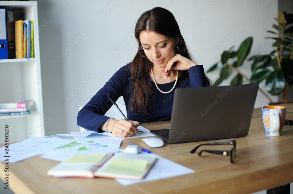 Portrait of a serious businesswoman using laptop in office Portrait of a serious businesswoman using laptop in office