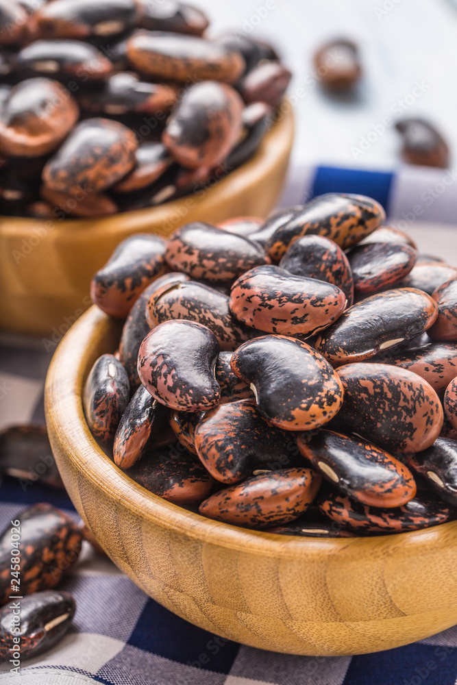 Uncooked beans in wooden bowles on kitchen table. Uncooked beans in wooden bowles on kitchen table.
