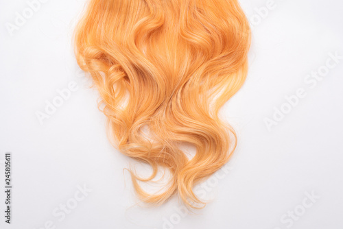 Human, natural honey-colored blond hair on white isolated background. Stylish, fashionable colors this year. Honey blonde shaken, wave and undulating hair. An example of hairstyle.