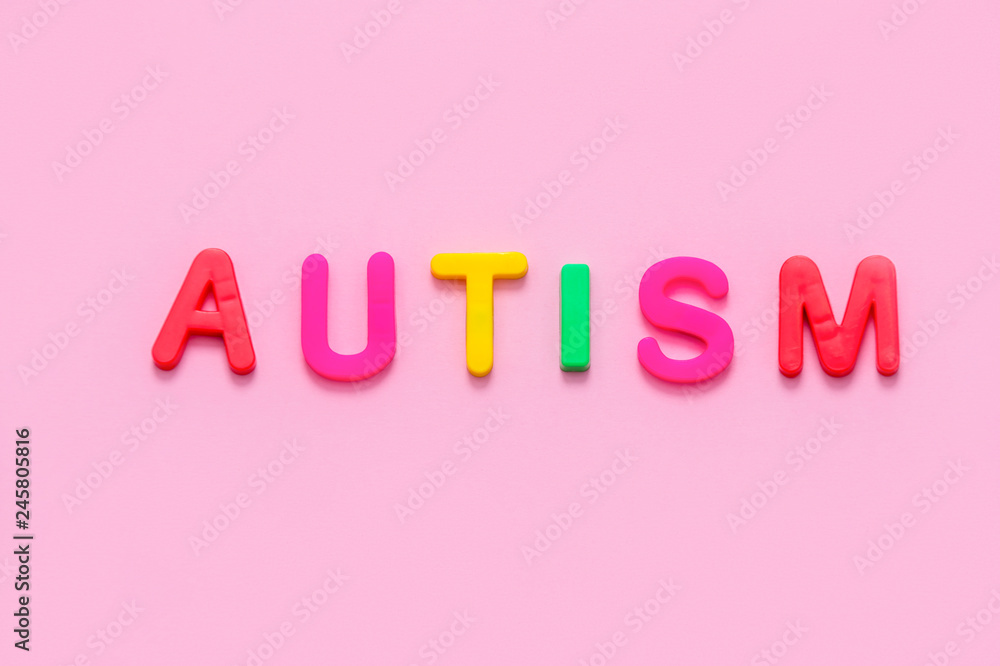 Word AUTISM on pink background, top view Word AUTISM on pink background, top view