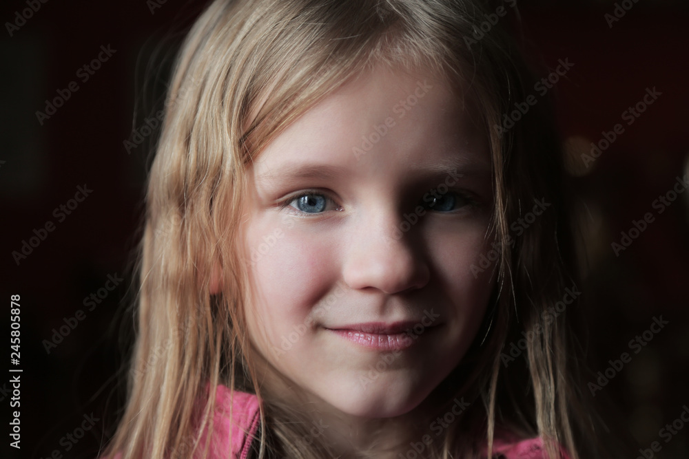smiling blond little girl looking at the camera. Closeup portrait on dark background smiling blond little girl looking at the camera. Closeup portrait on dark background