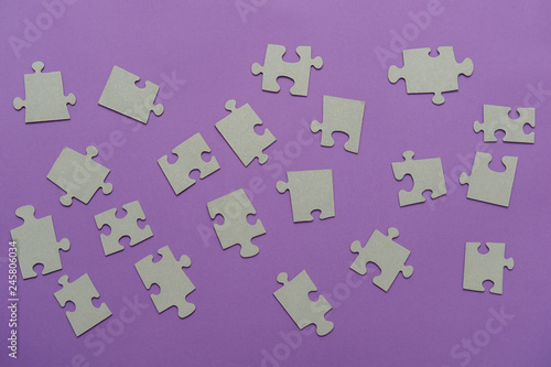 Puzzles on a purple background as a symbol of autism. Conceptual vision of the problem of autistic children