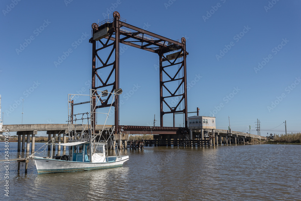 Vertical lift bridge over river with fishing boat