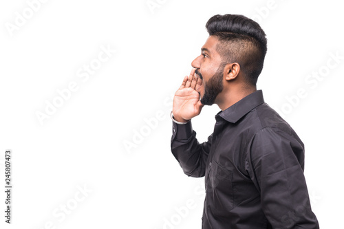 Konstfotografi Portrait of Indian guy shouting loud, mouth open and hand cupped beside