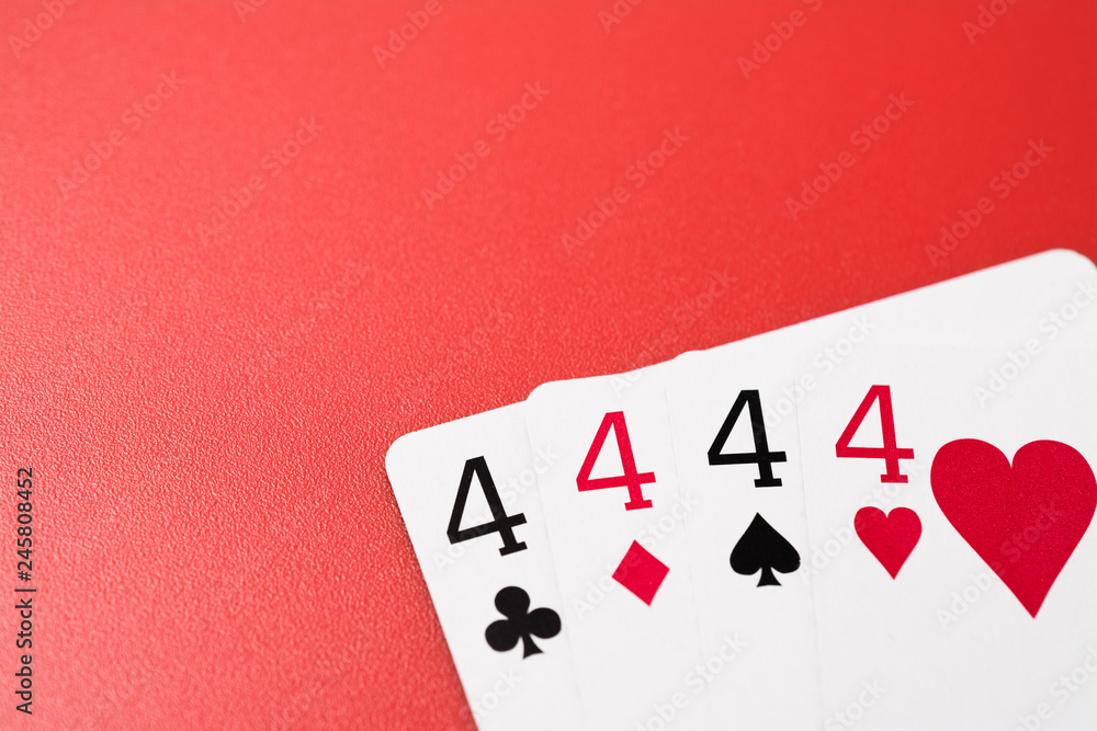 four four playing cards on a red background