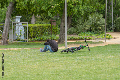 Ciclista descansa junto a la bicicleta sobre la hierba