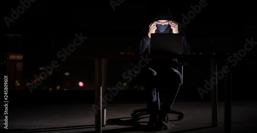 hacker using laptop computer while working in dark office © .shock