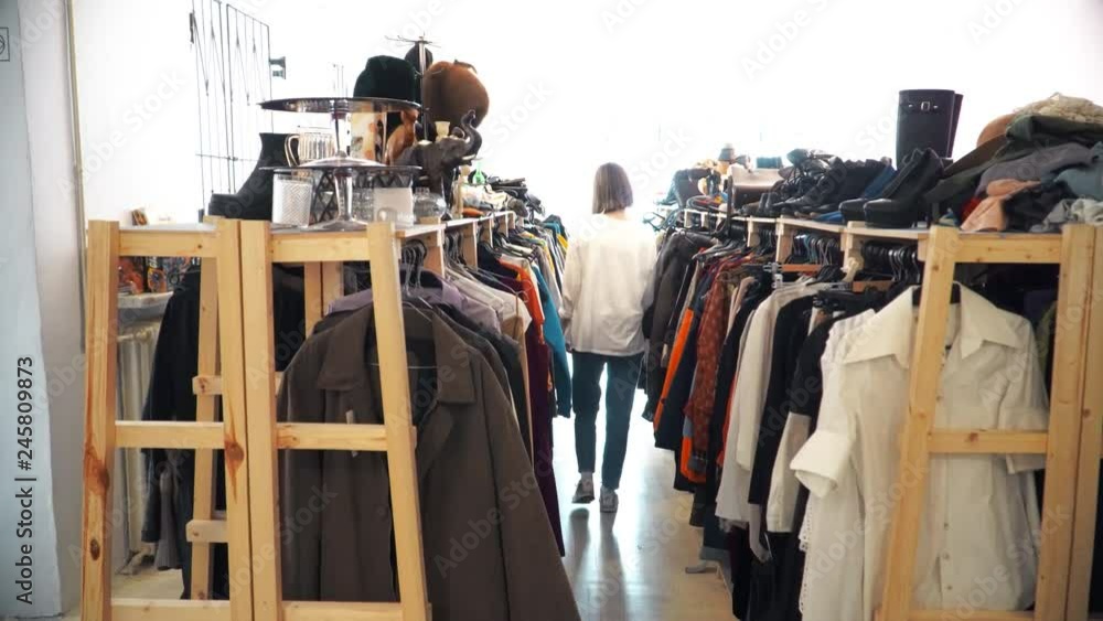 young girl chooses clothes in second hand, recycling, save the planet, ecology young girl chooses clothes in second hand, recycling, save the planet, ecology