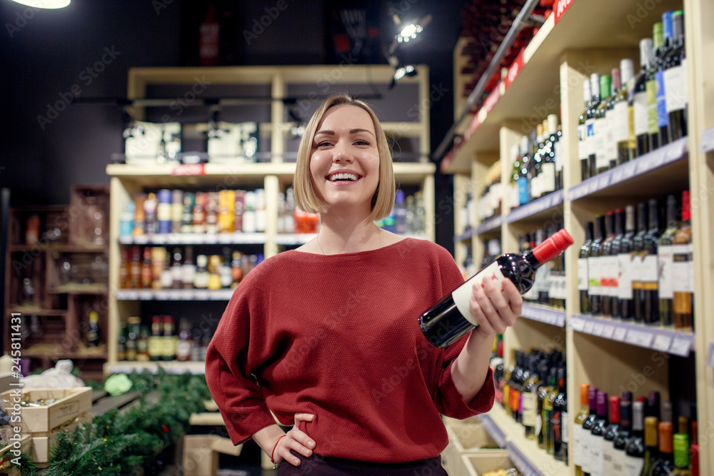 Photo of young brunette with bottle of wine in hand Photo of young brunette with bottle of wine in hand
