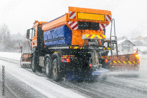 Snowplow truck removing dirty snow from city street or highway during heavy snowfalls. Traffic road situation. Weather forecast for drivers. Seasonal road maintenance