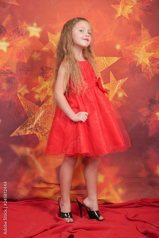 pretty cute caucasian child girl in red evening dress and mother's high