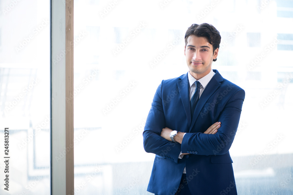 Young handsome businessman standing at the window Young handsome businessman standing at the window